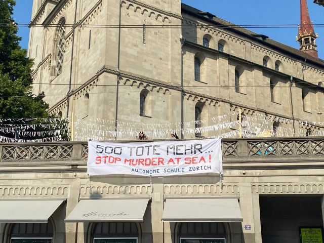 Ein grosser Banner hängt neben dem Grossmünster: "500 Tote mehr! Stop murder at sea! Autonome Schule Zürich"